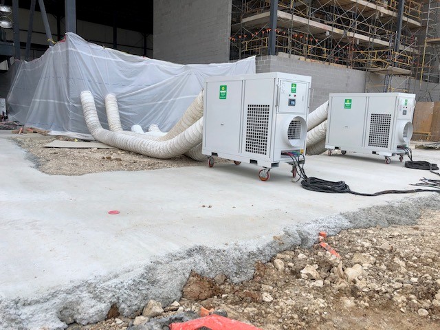 Portable air conditioners installed at a construction site.