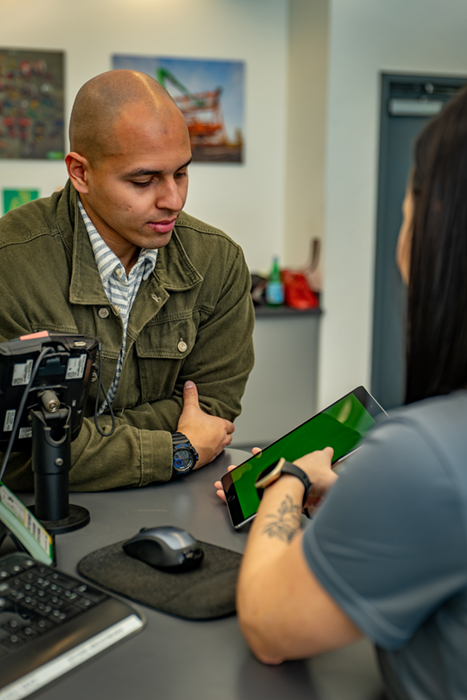 A customer inside of a branch store looking at a tablet with an employee.